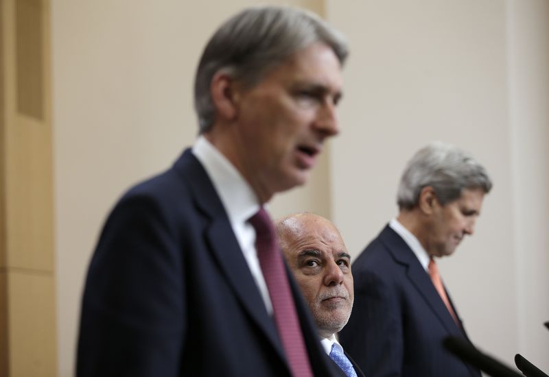 © Reuters. Iraq's Prime Minister Haider al-Abadi and U.S. Secretary of State John Kerry listen as Britain's Foreign Secretary Philip Hammond speaks during a news conference at the Foreign Office in London