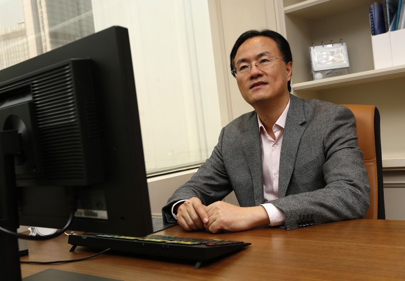 © Reuters. Managing Director of All-Stars Investment Limited Ji poses in front of his desk at his office in Hong Kong J