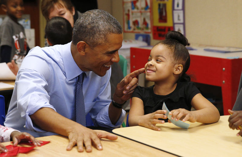 © Reuters. U.S. President Barack Obama touches the cheek of Akira Cooper during a visit to the Community Children's Center in Lawrence