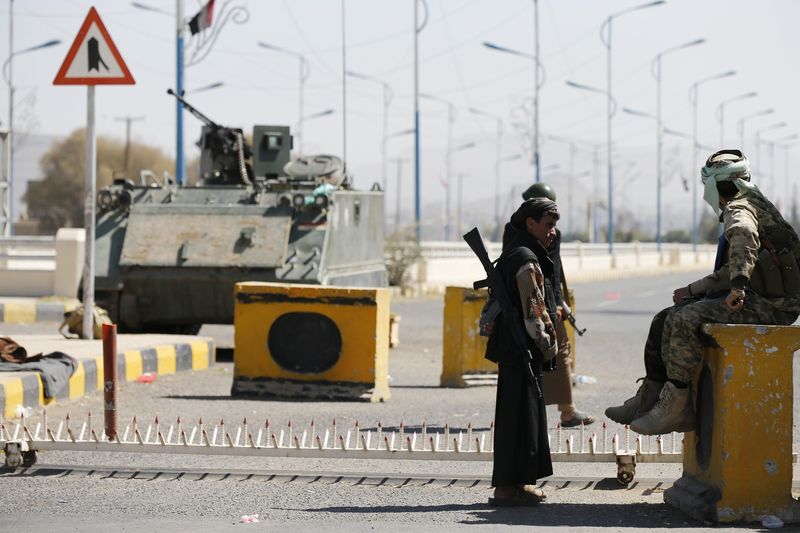 © Reuters. Houthi fighters secure an entrance to the presidential palace in Sanaa