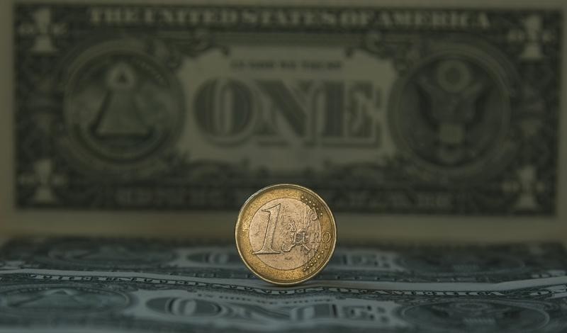 © Reuters. Монета валюты евро на фоне долларовой купюры в Мадриде