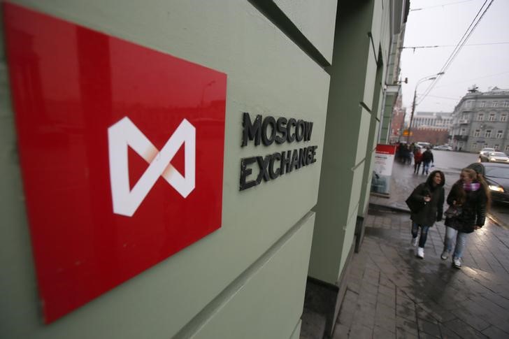 © Reuters. Люди проходят мимо вывески Московской биржи