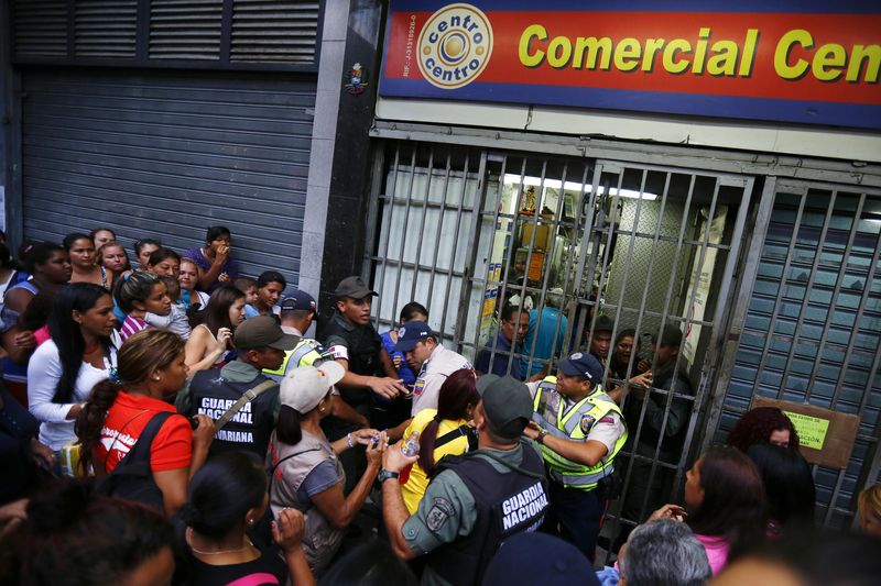 © Reuters. Pessoas fazem fila em porta de mercado no centro de Caracas