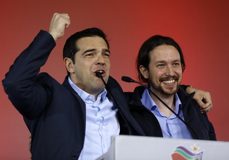 © Reuters. Greek head of Syriza party, Tsipras addresses supporters as Podemos party Secretary General Iglesias smiles during a campaign rally in central Athen