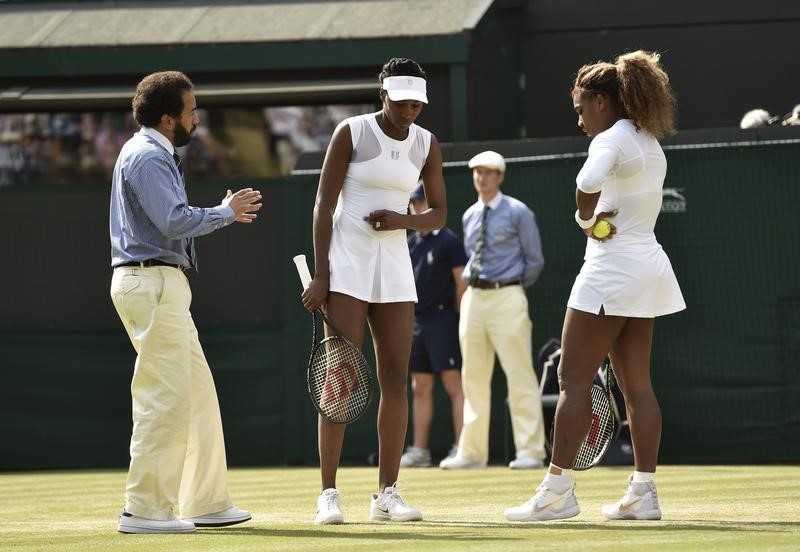 © Reuters. The umpire speaks to Serena and Venus Williams as Serena appeared unwell before retiring from their women's doubles tennis match against Kristina Barrois of Germany and Stefanie Voegele of Switzerland at the Wimbledon Tennis Championships, in London