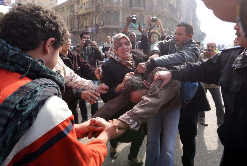 © Reuters. Supporters of an anti-Muslim Brotherhood group hit a supporter of ousted Egyptian President Mohamed Mursi and the Muslim Brotherhood at Talaat Harb Square in Cairo,