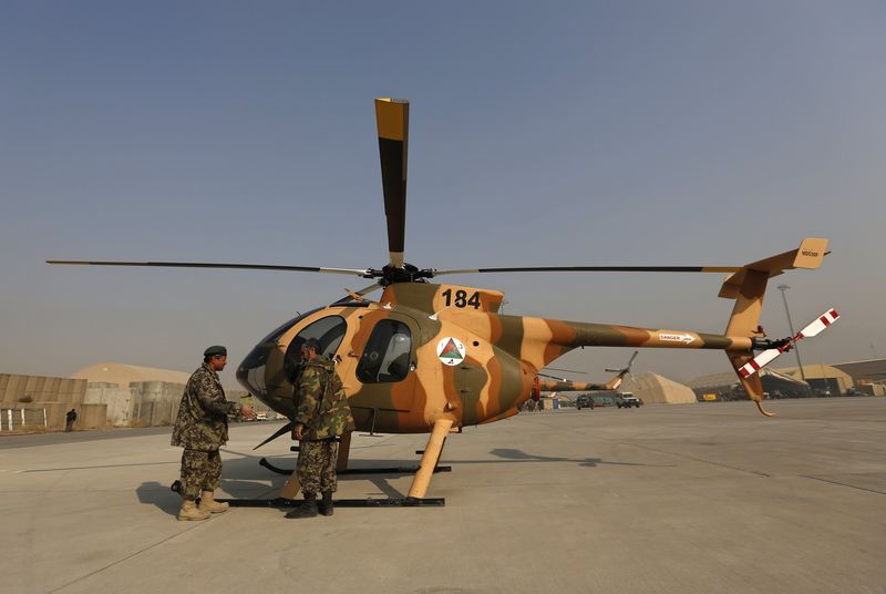 © Reuters. Members of the Afghan Air Force crew stand next to a helicopter at the military airport in Kabul