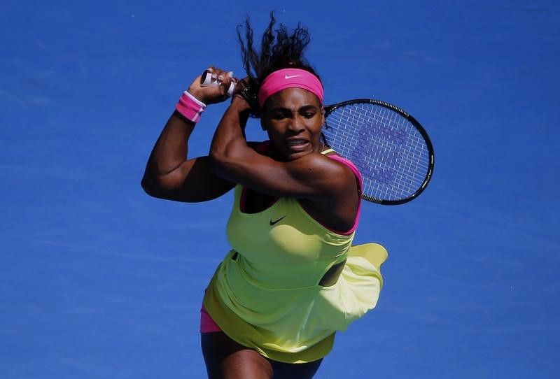 © Reuters. Williams of the U.S. hits a return to Muguruza of Spain during their women's singles fourth round match at the Australian Open 2015 tennis tournament in Melbourne 