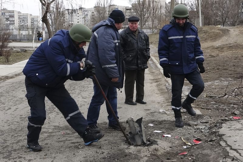 © Reuters. A rescue worker removes remains of a shell on a street in Mariupol, eastern Ukraine