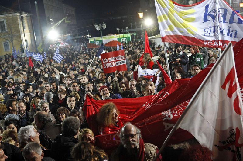 © Reuters. Supporters of radical leftist Syriza party chant slogans and wave Greek national and other flags after winning elections in Athens