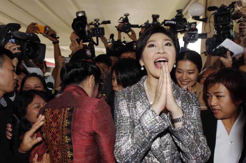 © Reuters. Ousted former Prime Minister Yingluck Shinawatra greets in a traditional way as she leave Parliament after delivering a statement during the National Legislative Assembly meeting in Bangkok