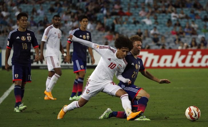 © Reuters. UAE's Omar Abdulrahman fights for the ball against Japan's Gotoku Sakai during their Asian Cup quarter-final soccer match at the Stadium Australia in Sydney