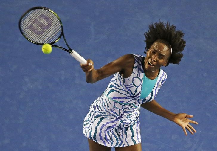 © Reuters. Venus of the U.S. hits a return to Radwanska of Poland during their women's singles match at the Australian Open 2015 tennis tournament in Melbourne 