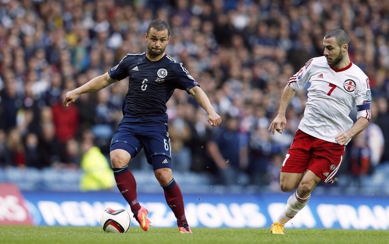 © Reuters. Scotland's Maloney is challenged by Georgia's Kankava during their Euro 2016 qualification match in Glasgow
