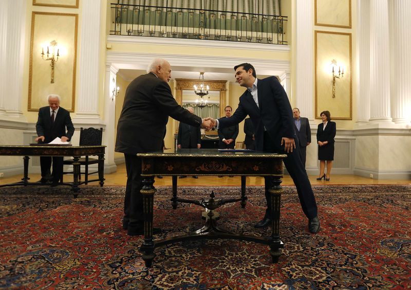 © Reuters. Alexis Tsipras (dx) stringe la mano al presidente greco Karolos Papoulias durante il giuramento