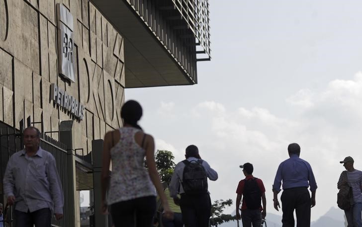 © Reuters. People walk past Brazilian Oil company Petrobras's headquarters in Rio de Janeiro