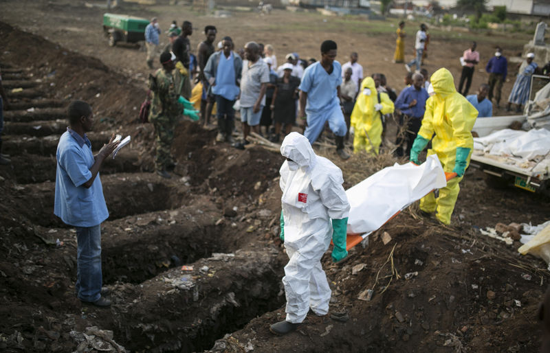 © Reuters. Profissionais de saúde enterram vítima de Ebola em Freetown, Serra Leoa