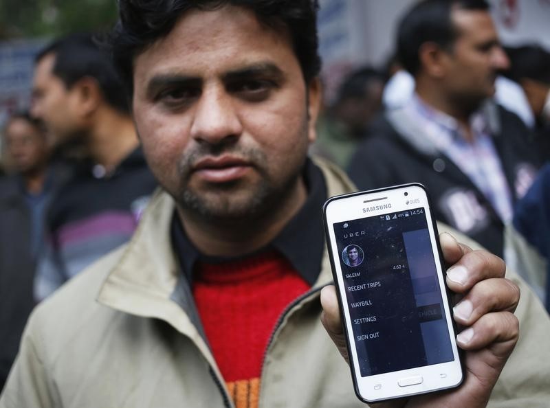 © Reuters. An Uber taxi driver shows an application software in his mobile phone used to track the taxi's location, during a protest against the ban on online taxi services, in New Delhi