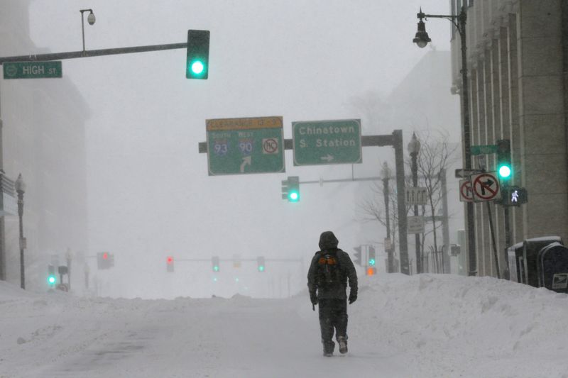 © Reuters. A pedestrian walks along a snow-covered street  during a winter blizzard in Boston