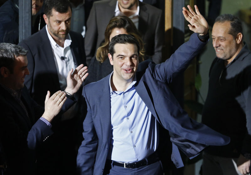 © Reuters. Head of radical leftist Syriza party Tsipras waves while leaving the party headquarters after winning the elections in Athens