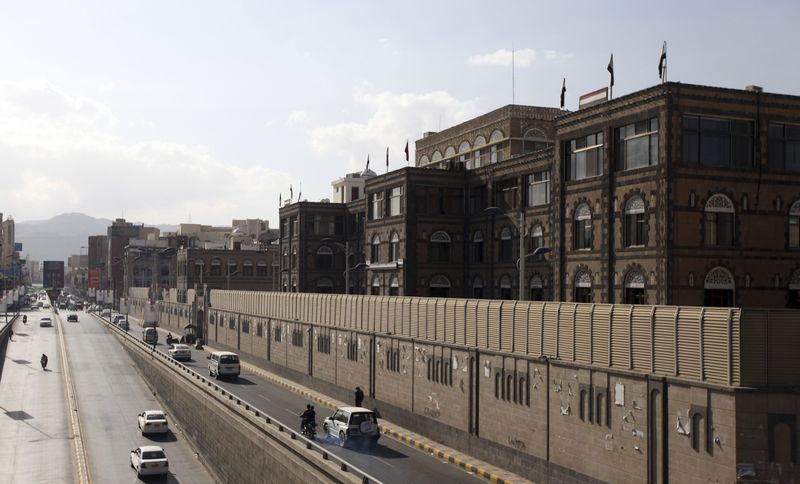 © Reuters. Vehicles drive past the office building of Ahmed Awadh bin Mubarak, in Sanaa