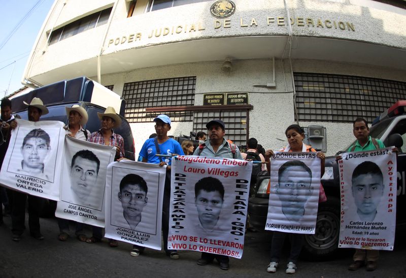 © Reuters. Relatives hold up posters of the 43 missing students of the Ayotzinapa Teacher Training College during a protest outside the federal court in Chilpancingo, in the Mexican state of Guerrero