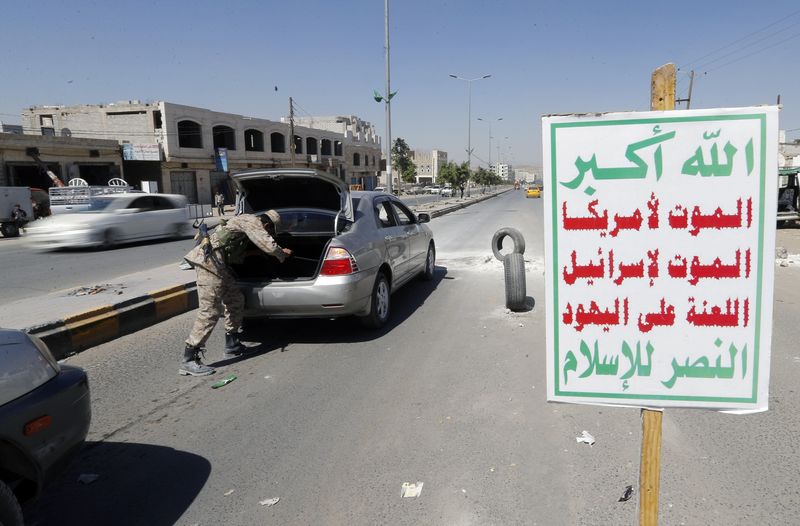 © Reuters. Militante houthi em uniforme militar inspeciona um carro em Sanaa