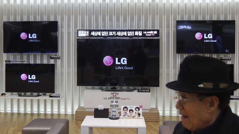 © Reuters. A customer walks in front of LG TV sets which are made with LG Display flat screens, at a store in Seoul
