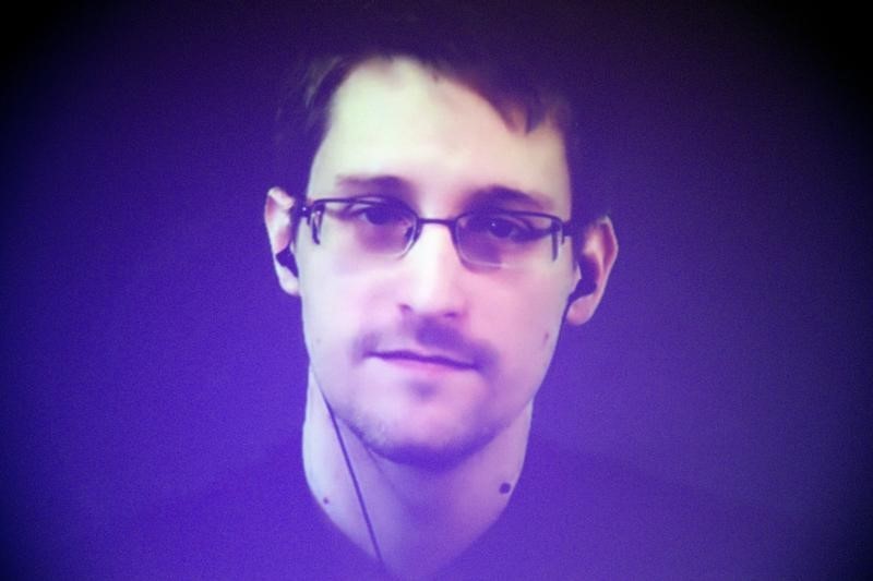 © Reuters. Former US National Security Agency contractor Edward Snowden, who is in Moscow, is seen on a giant screen during a live video conference for an interview as part of Amnesty International's annual Write for Rights campaign at the Gaite Lyrique in Paris