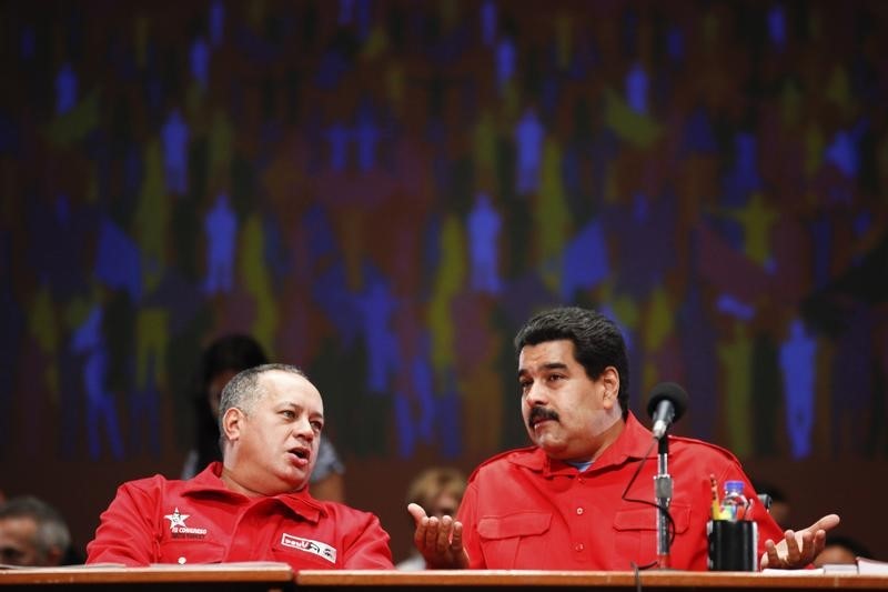 © Reuters. Venezuela's President Nicolas Maduro talks to National Assembly President Diosdado Cabello during a meeting with members of the United Socialist party in Caracas