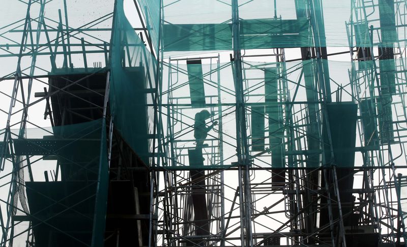 © Reuters. Worker arranges steel structure at a construction site in Hanoi