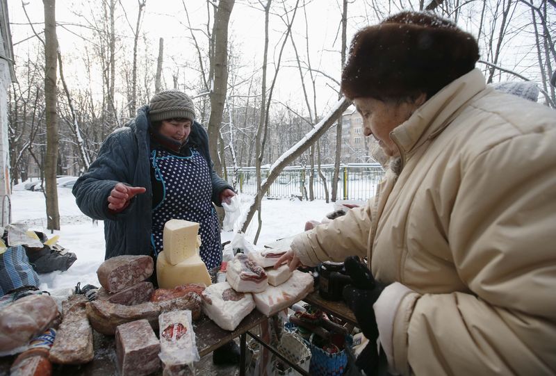 © Reuters. Woman points at a cut of meat as a street vendor sells food in the yard of an apartment building in Moscow