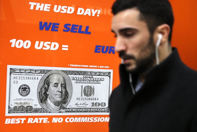 © Reuters. Человек проходит мимо пункта обмена валюты в Мадриде