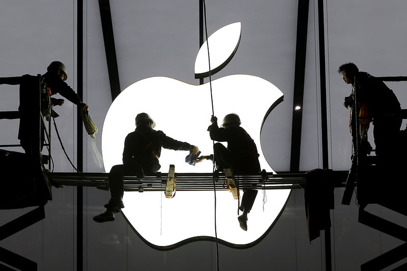 © Reuters. Рабочие монтируют логотип Apple на магазине компании в Ханчжоу