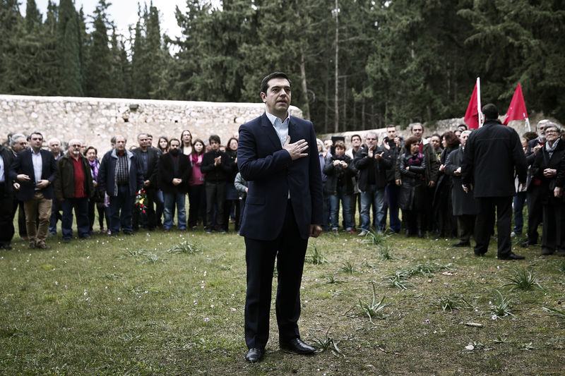 © Reuters. Greece's newly-appointed PM Tsipras places his hand on his heart during a ceremony at the Kessariani shooting range site where hundreds of members of the Greek Resistance were executed by Nazi occupation forces during World War II in Athens