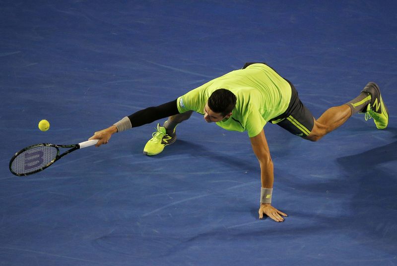 © Reuters. Milos Raonic of Canada stretches to hit a return against Novak Djokovic of Serbia during their men's singles quarter-final match at the Australian Open 2015 tennis tournament in Melbourne