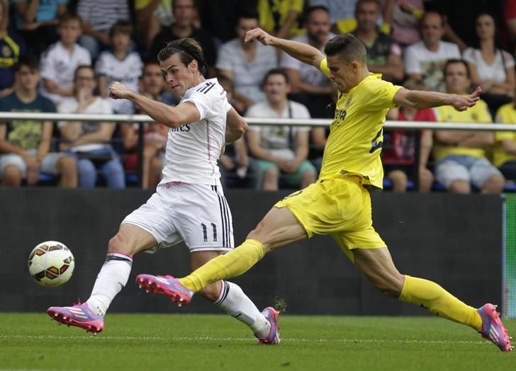 © Reuters. Real Madrid's Bale and Villareal's Gabriel fight for the ball during their Spanish first division soccer match at the Madrigal stadium in Villarreal