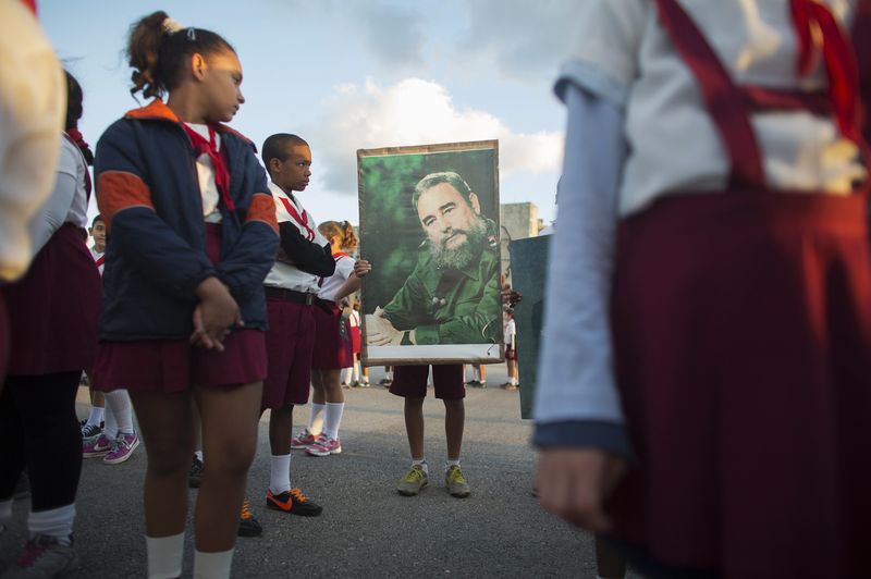 © Reuters. A student holds a photograph of Cuba's former President Fidel Castro near the memorial of Jose Marti on Revolution Square in Havana