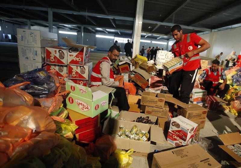 © Reuters. Libyan Red Crescent workers prepare parcels of food aid to be delivered to civilians fleeing violence in the eastern city of Benghazi, in Misrata