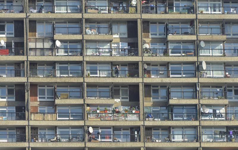 © Reuters. A man stands on a balcony in a residential high rise block of flats in North Kensington in central London