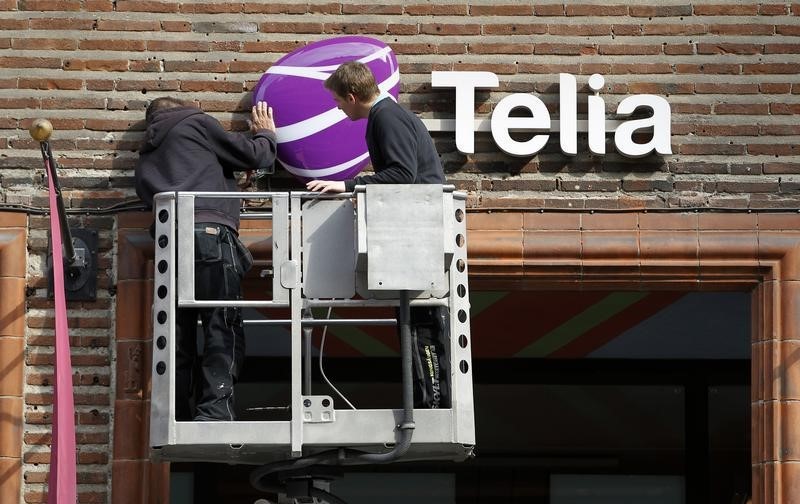 © Reuters. Рабочие устанавливают новый логотип TeliaSonera на офисе продаж в Стокгольме