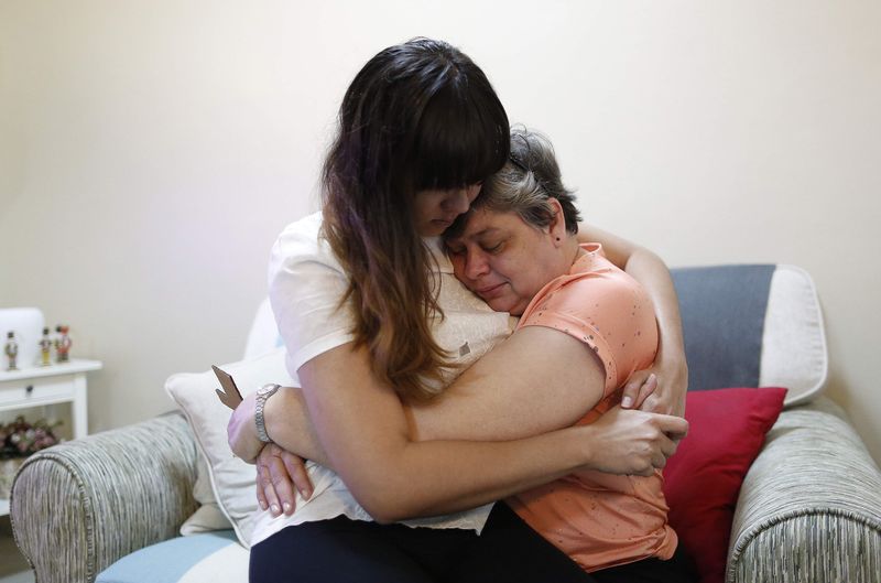 © Reuters. Daughter Michelle Gomes and wife Jacquita Gonzales of in-flight supervisor Patrick Francis Gomes, who was aboard the missing Malaysia Airlines Flight MH370, comfort each other at their home in Kuala Lumpur