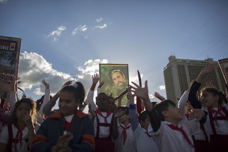 © Reuters. A student holds up a photograph of Cuba's former President Fidel Castro at the memorial of Jose Marti on Revolution Square in Havana