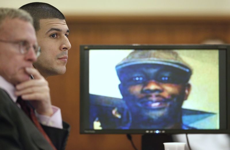 © Reuters. Former New England Patriots football player Aaron Hernandez listens during his trial as defense attorney Charles Rankin looks on while an image of Odin Lloyd is displayed on a monitor in Fall River Massachusetts
