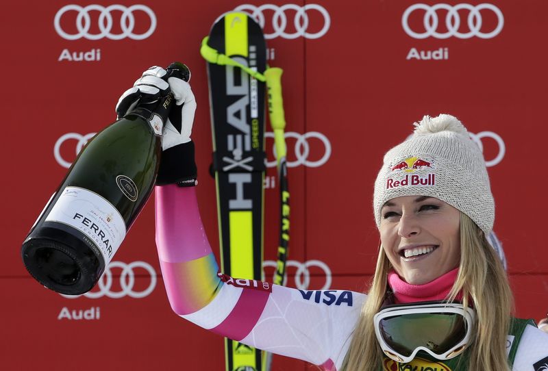 © Reuters. Lindsey Vonn of the U.S. celebrates with champagne on the podium after winning the women's World Cup Super-G skiing race in Cortina D'Ampezzo