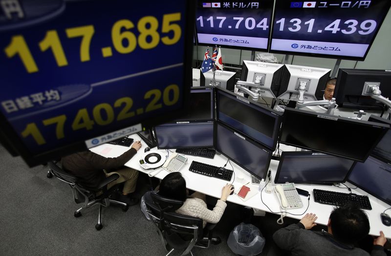 © Reuters. Employees of a foreign exchange trading company work under monitors displaying the exchange rates between the Japanese yen and the U.S. dollar, yen against the Euro, and Japan's Nikkei average, in Tokyo