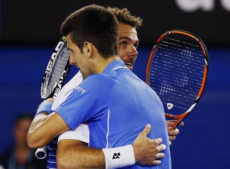 © Reuters. Djokovic of Serbia hugs Wawrinka of Switzerland after winning their men's singles semi-final match at the Australian Open 2015 tennis tournament in Melbourne