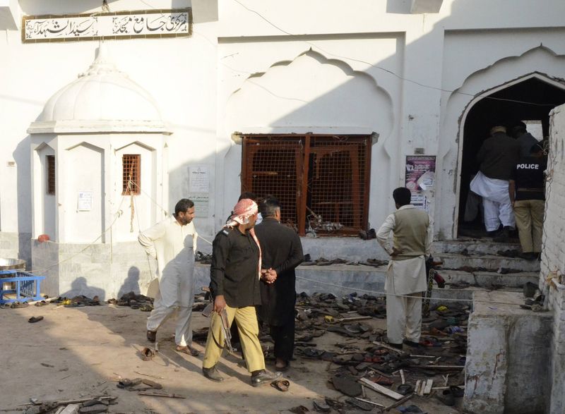 © Reuters. Moradores e policiais após explosão em mesquita xiita de Shikarpur