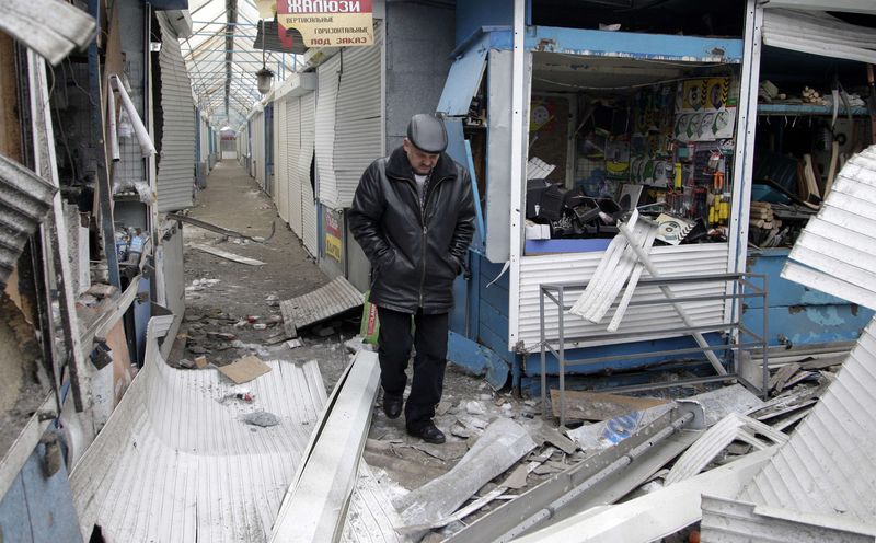 © Reuters. Homem passa por loja danificada por recente ataque em mercado de Donetsk, no leste da Ucrânia