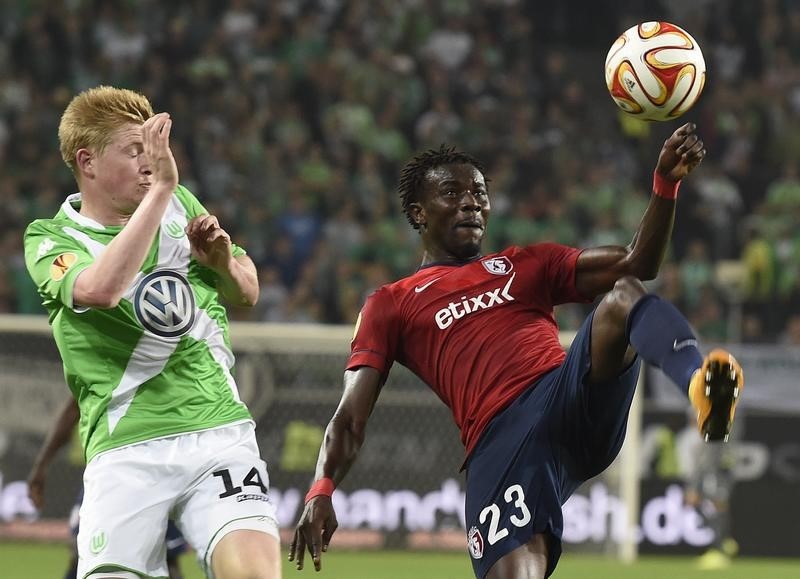 © Reuters. VfL Wolfsburg's de Bruyne and Lille's Souare fight for the ball during their Group H Europa League soccer match in Wolfsburg